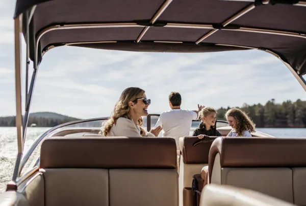 Happy family enjoying a boat rental on a Massachusetts lake on a sunny day