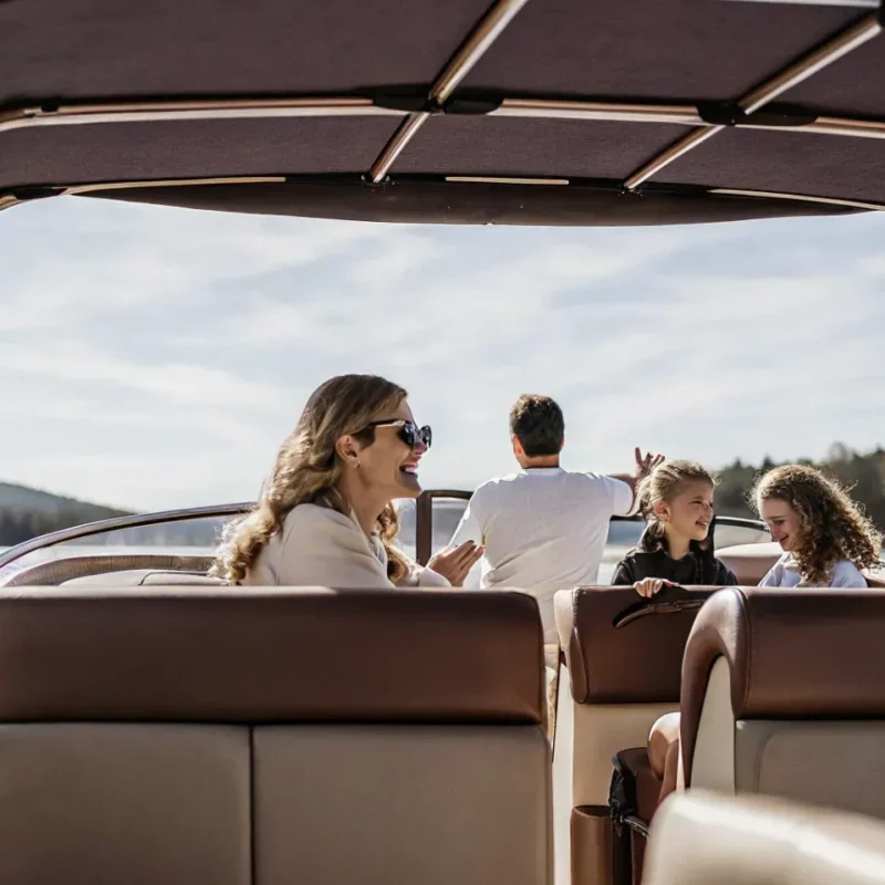 Happy family enjoying a boat rental on a Massachusetts lake on a sunny day