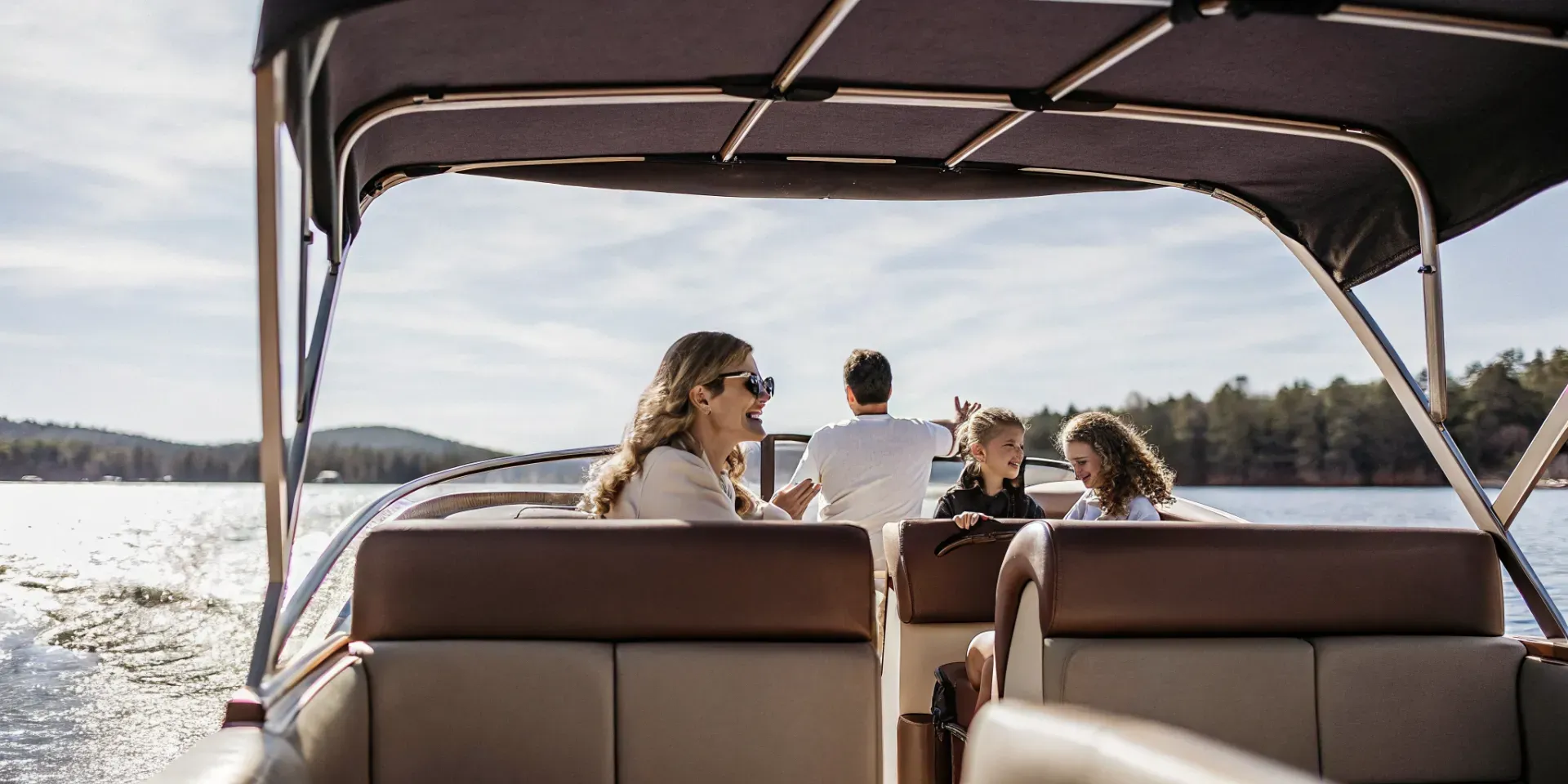 Happy family enjoying a boat rental on a Massachusetts lake on a sunny day