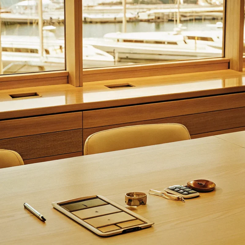 Calculating how much a boat club membership is at a desk with a marina view.