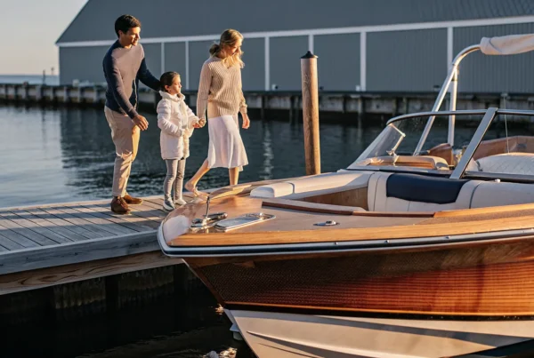 Family standing beside a boat at a New England marina during golden hour