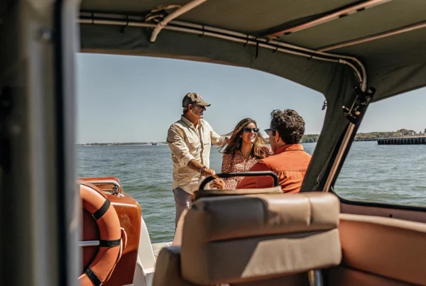 Family enjoying a sunny day boating on Boston Harbor with Massachusetts coastline in the background