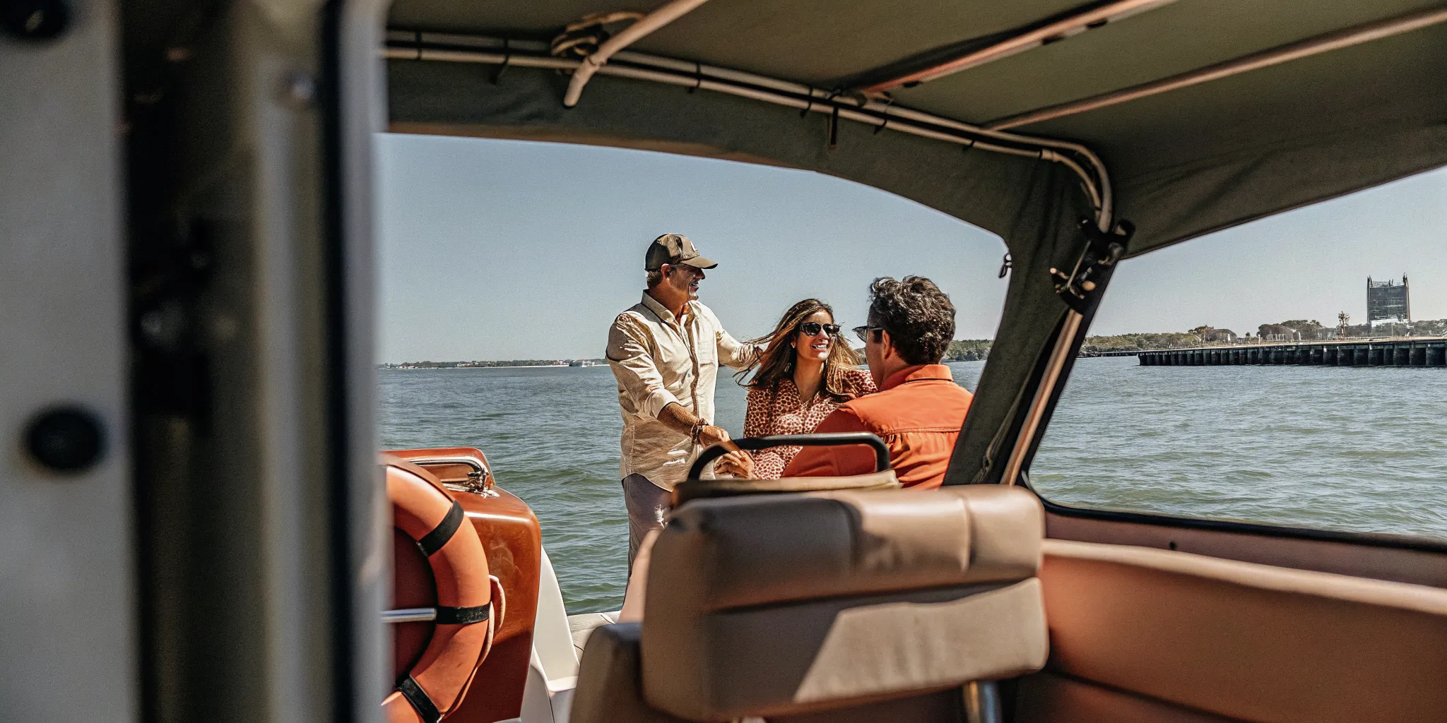 Family enjoying a sunny day boating on Boston Harbor with Massachusetts coastline in the background