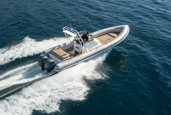 A fast RIB boat with twin engines speeds across the open water.