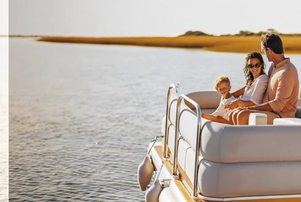 Family relaxing on a Carefree Boat Club boat cruising a calm New England harbor on a sunny day