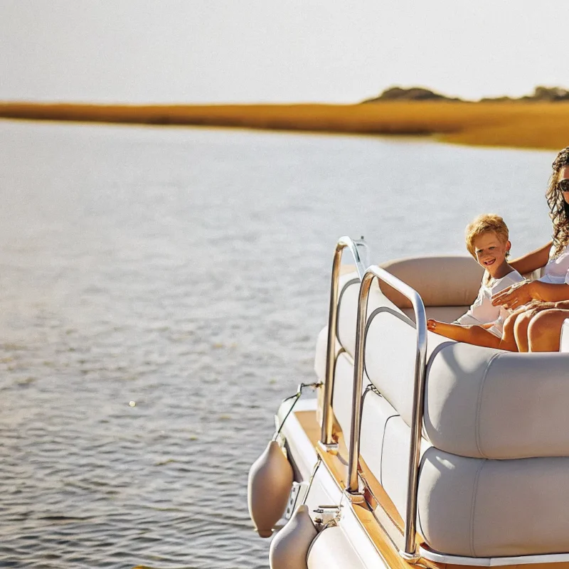 Family relaxing on a Carefree Boat Club boat cruising a calm New England harbor on a sunny day
